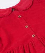 A close up of the button closure on the back of the Frugi Red Robin Corduroy Kids' Christmas Organic Dress. This red cord dress is a part of a wide range of organic cotton clothing for children available here at Babipur.