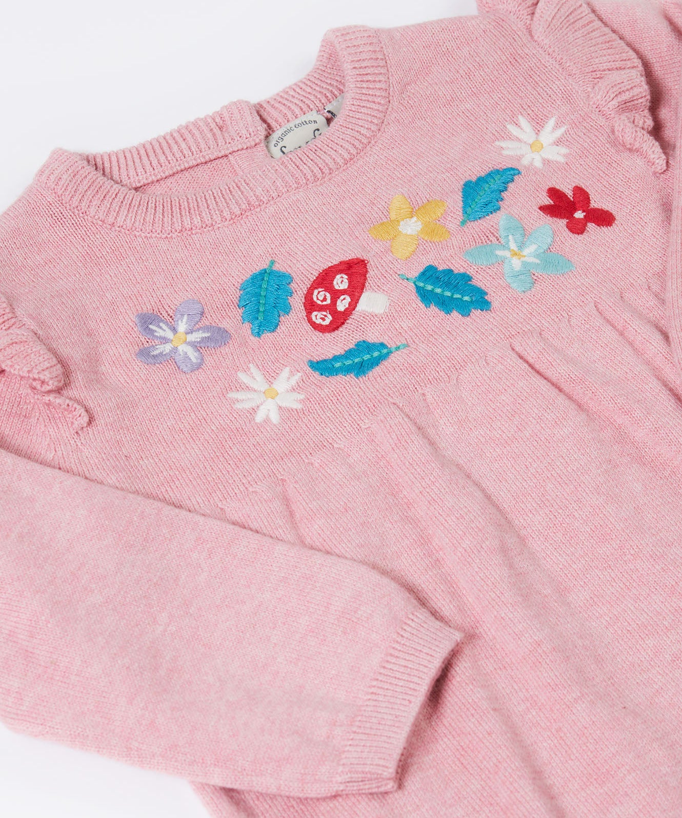 A close up of the Frugi kids remi knitted romper in pink marl /flowers showing the woodland inspired embroidery detail.