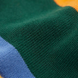 A close up of the penguin/ rainbow Frugi reversible voyager hat showing the bold striped design on GOTS organic cotton fabric.