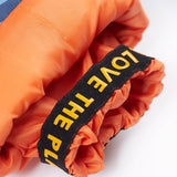 A close up of the Frugi penguin waddle snow and ski salopettes showing the orange snow cuff detail