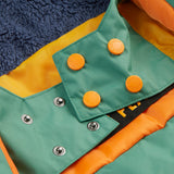 A close up of the Frugi kids snow and ski coat in green with a mountain scene print. Showing the thick navy fleece on the back and popper fasteners to adjust the size for a snug fit
