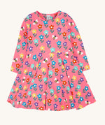 The Frugi Sofia skater dress with a fun flowers design on a tulip pink background. The dress has long sleeves.