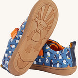 A view of the rubber soles on the Frugi Penguin Print Tide Low Top velcro closure leather children's shoes. The sole features the Frugi logo text in the middle of a mountain-scape scene with the words love the plant you play on featured within the design.