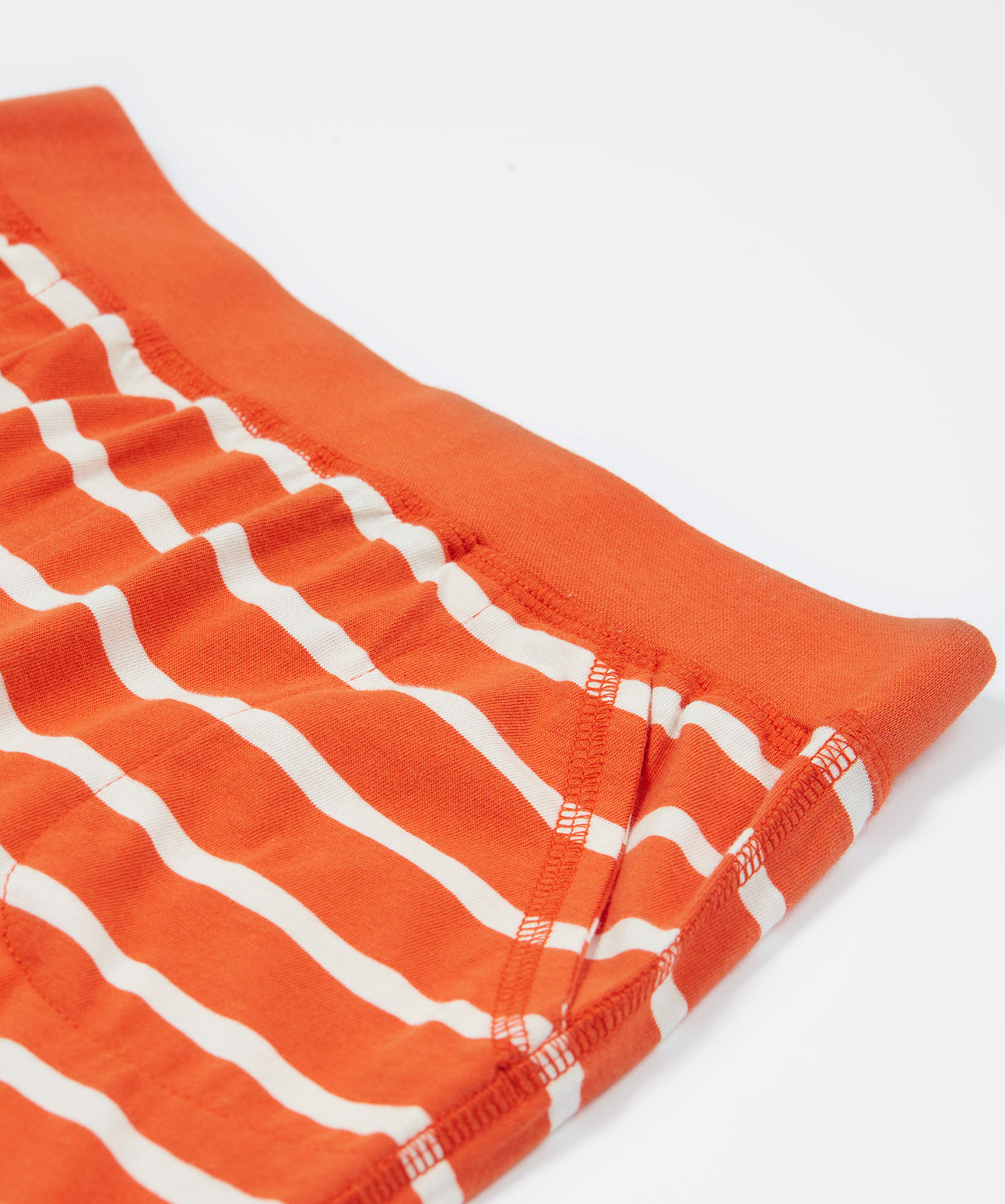 A close up of Frugi Stithian Shorts in Tiger Orange Breton's front pocket.