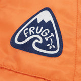 A close up of the Frugi toasty trail reversible jacket showing the brand patch stitched on the side pocket on orange post consumer recycled polyester fabric