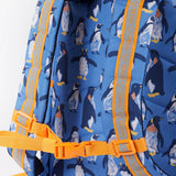 A close up of the Frugi kids trail blazing backpack in penguin waddle. Showing the shoulder strap detail and orange chest buckle connecting the shoulder straps