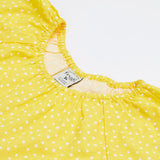 A close up of Frugi Dorothy Twirly Dress in its Rainbow Hotchpotch print, featuring a spotty yellow design.