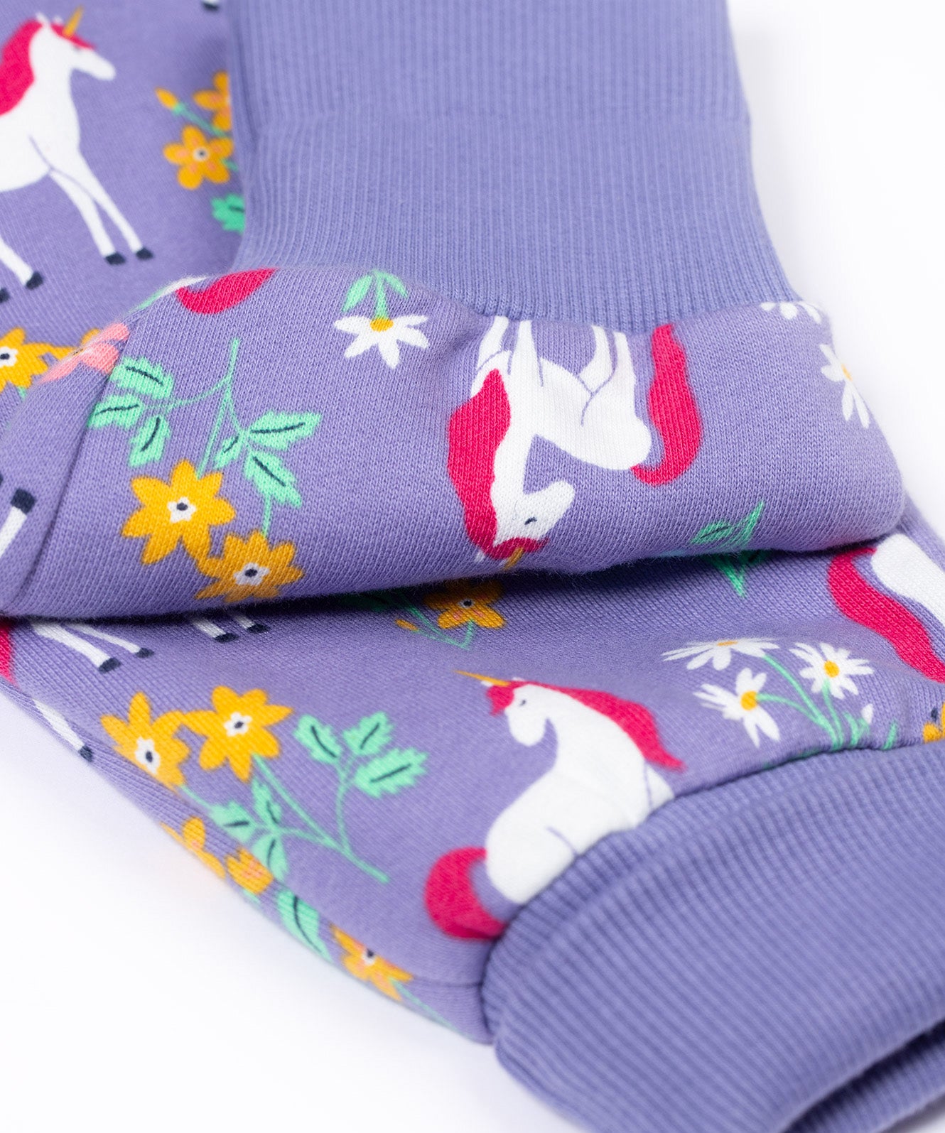 A close up of the fold-able cuffs on the Frugi Organic Cotton purple unicorn floral print Children's Big Snuggle Suit. This all in one snuggle suit is a part of a wide range of organic cotton clothing for children available here at Babipur.