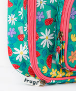 A close up of the Frugi kids pack a lunch bag in wild woods. Showing the pink trim and zip detail