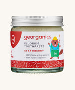 A jar of the kids strawberry fluoride toothpaste with a picture of a beaver on the jar on a cream background