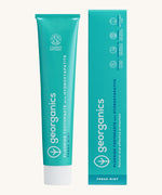 Front view of the Georganics fresh mint hydroxyapatite toothpaste. A light green tube with white and blue branding text next to matching cardboard packaging.
