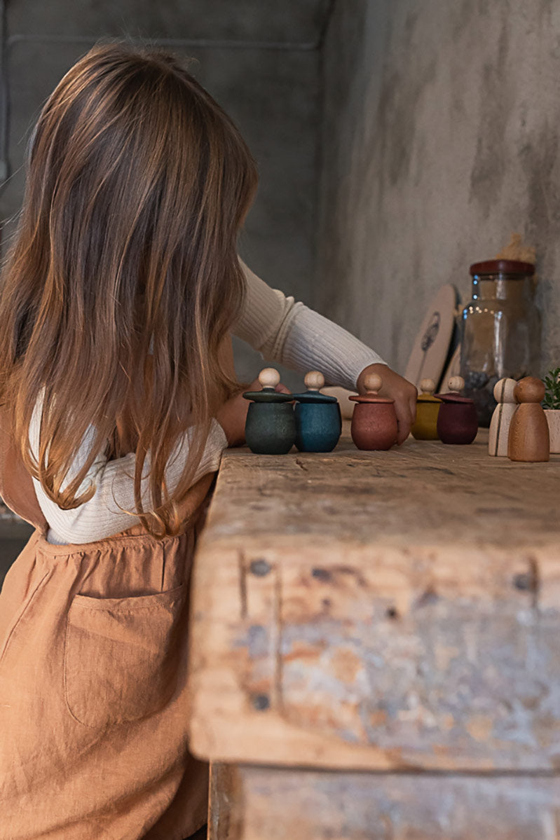 Green Grapat little things pot tipped over on a white background