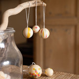 multicoloured patterned Grapat wooden balls hanging on a stick
