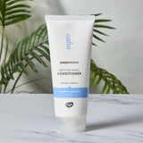 Green People Irritated Scalp Conditioner on a marble style surface.