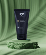 A tube of Green People no.10 Itch Away Shampoo placed on a  green coloured disc pictured against a green background.