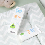 A tube of Organic Babies Nappy Cream Baby Balm placed on a changing mat next to the box.