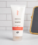 Green People Quinoa & Artichoke protein boost shampoo on a white surface in a bathroom.