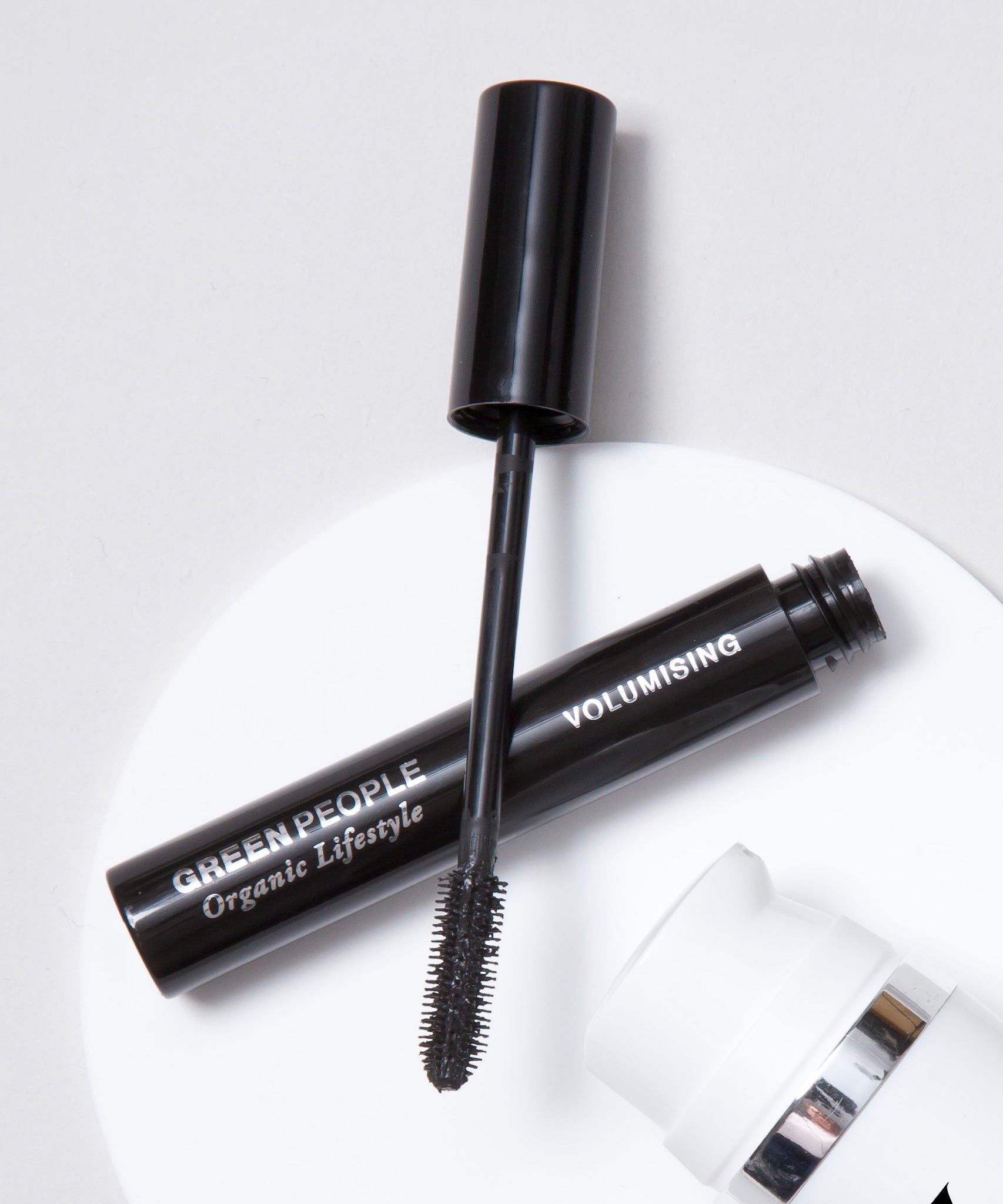 A close up of an open Green People Volumising Mascara showing the wand applicator brush.