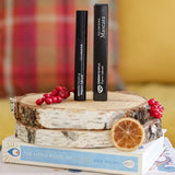 A pack of Green People Volumising Mascara on a log slice that has been placed on a pile of books.