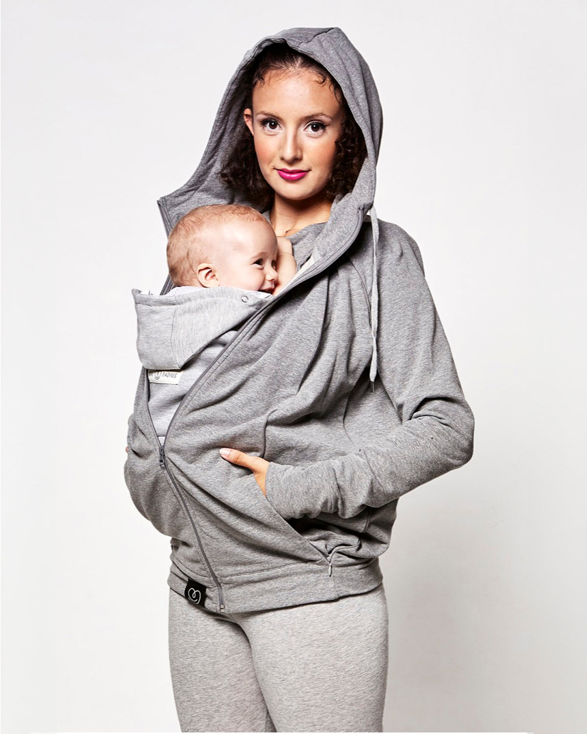 whilst holding a child . On a light grey background