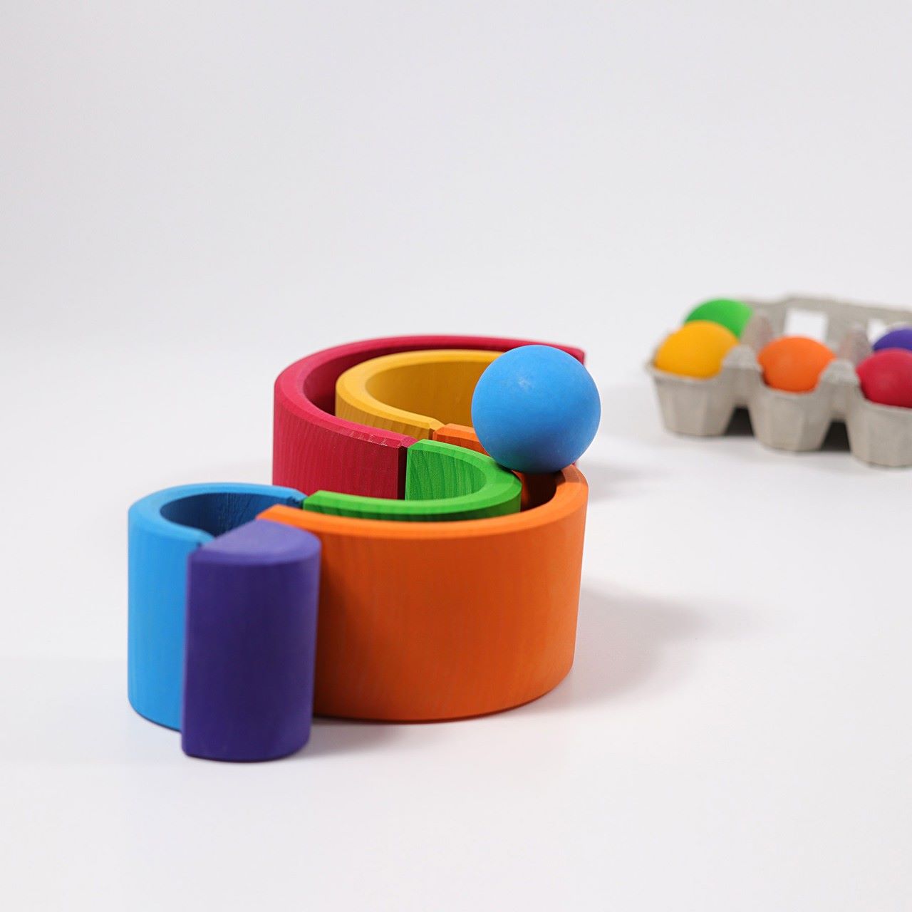 Grimm's Wooden Medium Rainbow as a ball run on a grey background