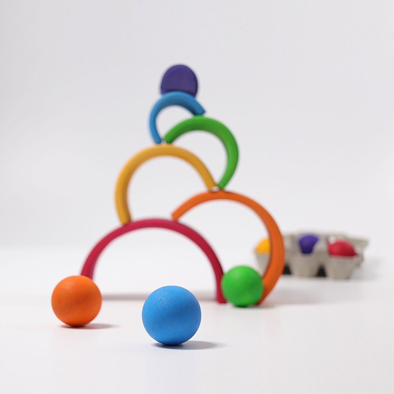 Grimm's Wooden Medium Rainbow as a ball run on a grey background