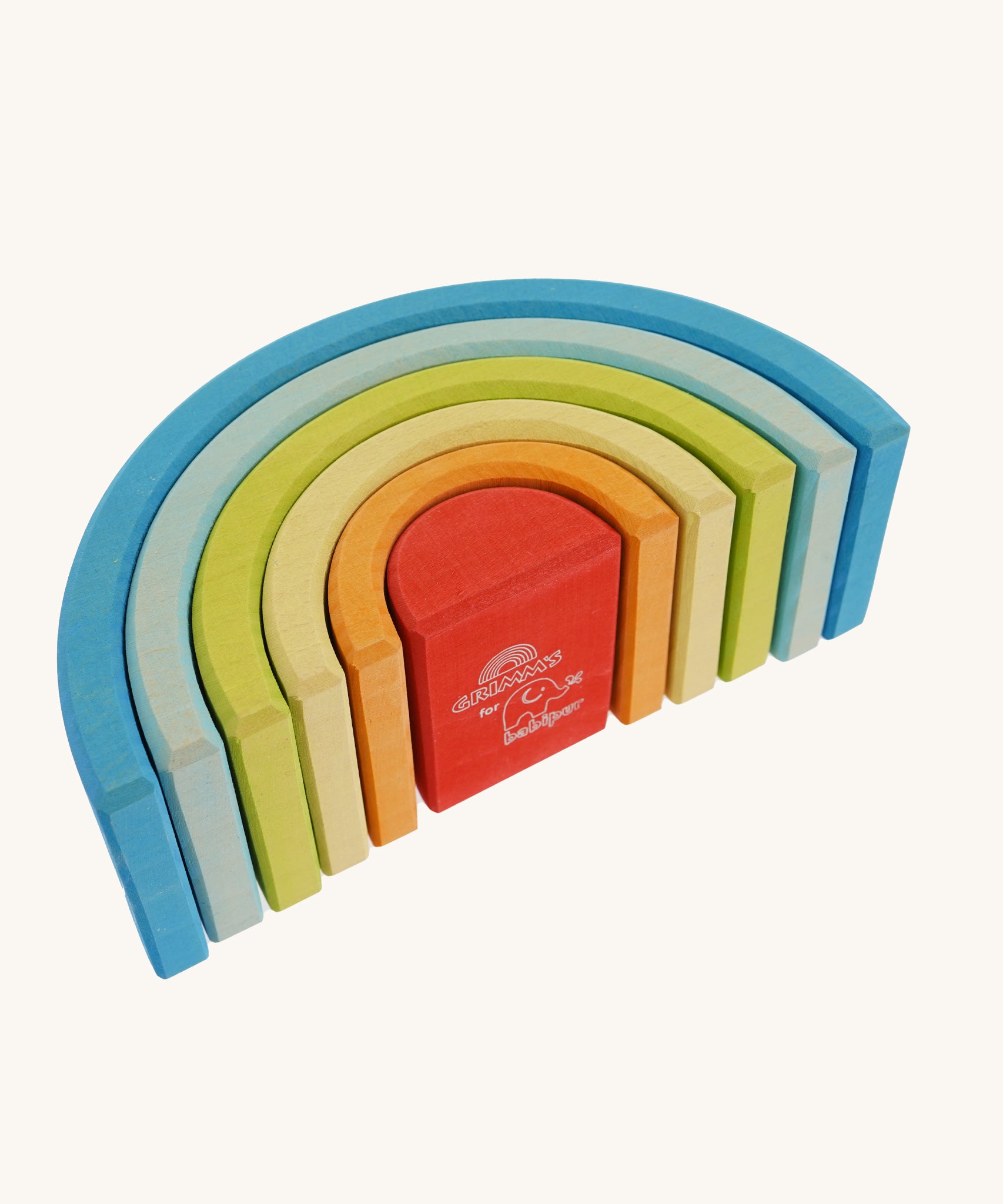 The Grimm's Babi Gwawr Sunrise 6 Piece Rainbow on a plain background. The rainbow is shown it's side showing the bottom of the rainbow. The Grimm's and babipur logo's can be seen on the bottom of the red piece.