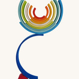 The Grimm's Gwawr Sunrise 12 Piece Rainbow on a plain background.  The pieces have been used to create a tall balancing stack.