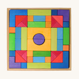 Grimm's wooden Blocks Basic Building Set 2. A set of colourful wooden toy building blocks in a wooden storage tray. The blocks are varous sizes and shapes inlcuding cubes, half cylinders, arches, triangles and more.