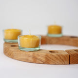 A wooden celebration ring from Grimms, with the beeswax tealights in glass holders