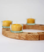 A wooden celebration ring from Grimms, with the beeswax tealights in glass holders