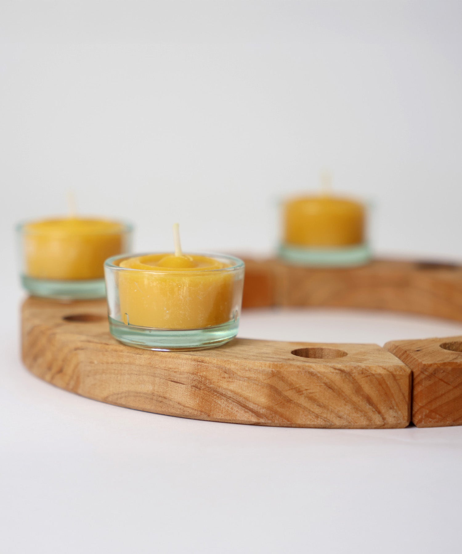 A wooden celebration ring from Grimms, with the beeswax tealights in glass holders