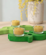 Grimm's beeswax tealights in glass holders, on a green wooden celebration spiral