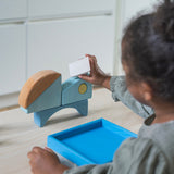 A child playing with the Grimm's blue boat Wooden Stacking Puzzle. The child is stacking the blocks on top of each other. These Grimm's toys are part of a wide range of wooden toys available here at Babipur.