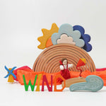 The Grimm's Wooden Weather Building Set set up along side the 12 piece natural rainbow and free standing letters. The scene depicts a windy day.