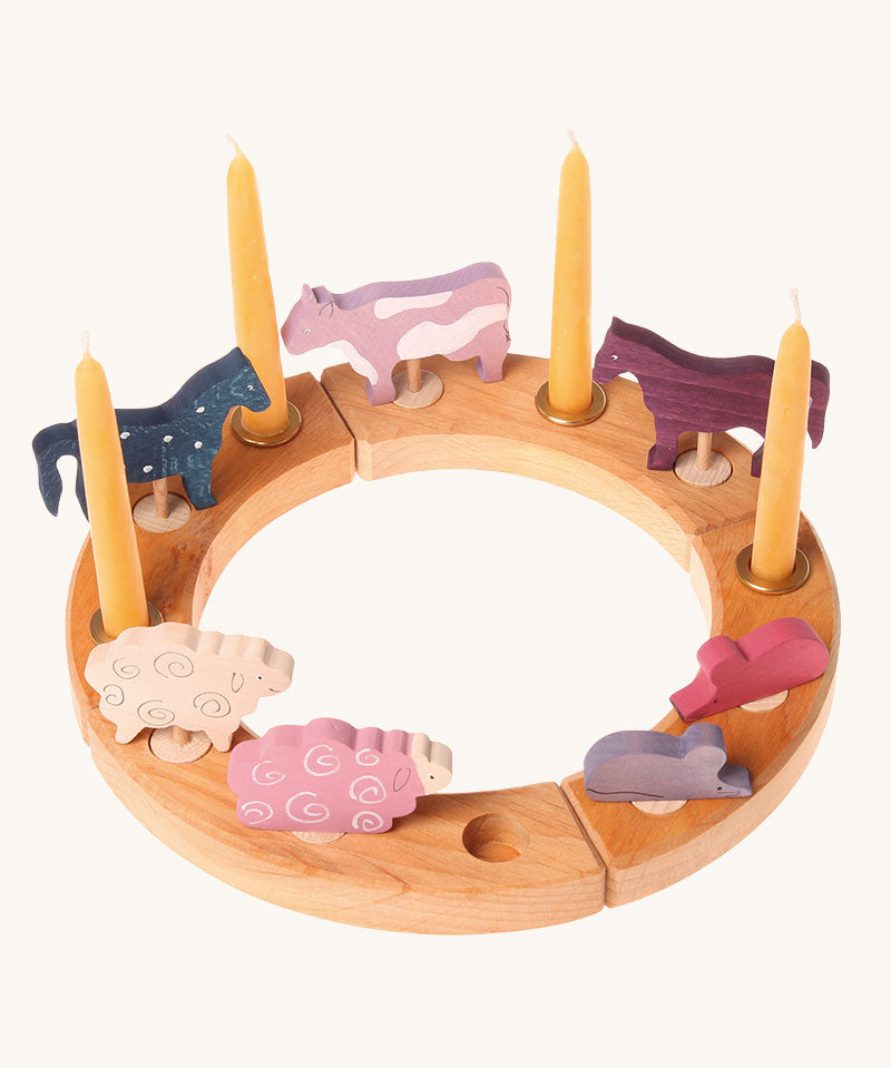 A natural Grimm's celebration figure decoreated with wooden figures and candles. These Waldorf inspired decorative figures are part of a wide range of wooden decorations for celebration rings available here at Babipur.