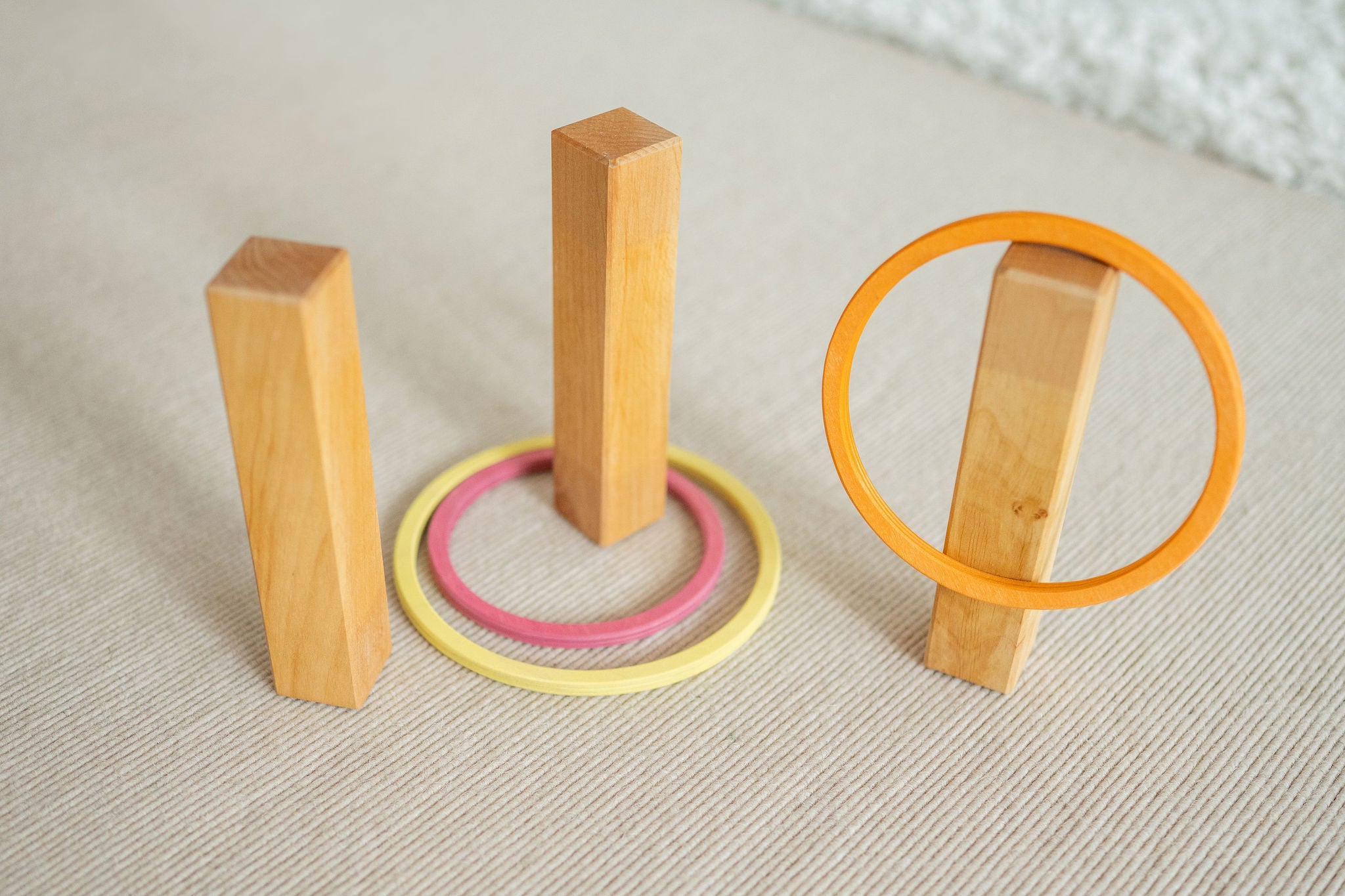 The concentric wooden rings by Grimm's, set up with wooden pillars to make a game of ring toss