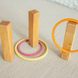 The concentric wooden rings by Grimm's, set up with wooden pillars to make a game of ring toss