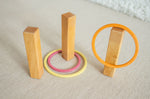 The concentric wooden rings by Grimm's, set up with wooden pillars to make a game of ring toss