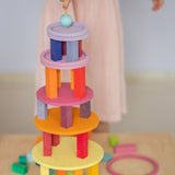 Grimm's wooden concentric circles and rings stacked into a colourful tower with wooden blocks, showcasing open-ended construction play.