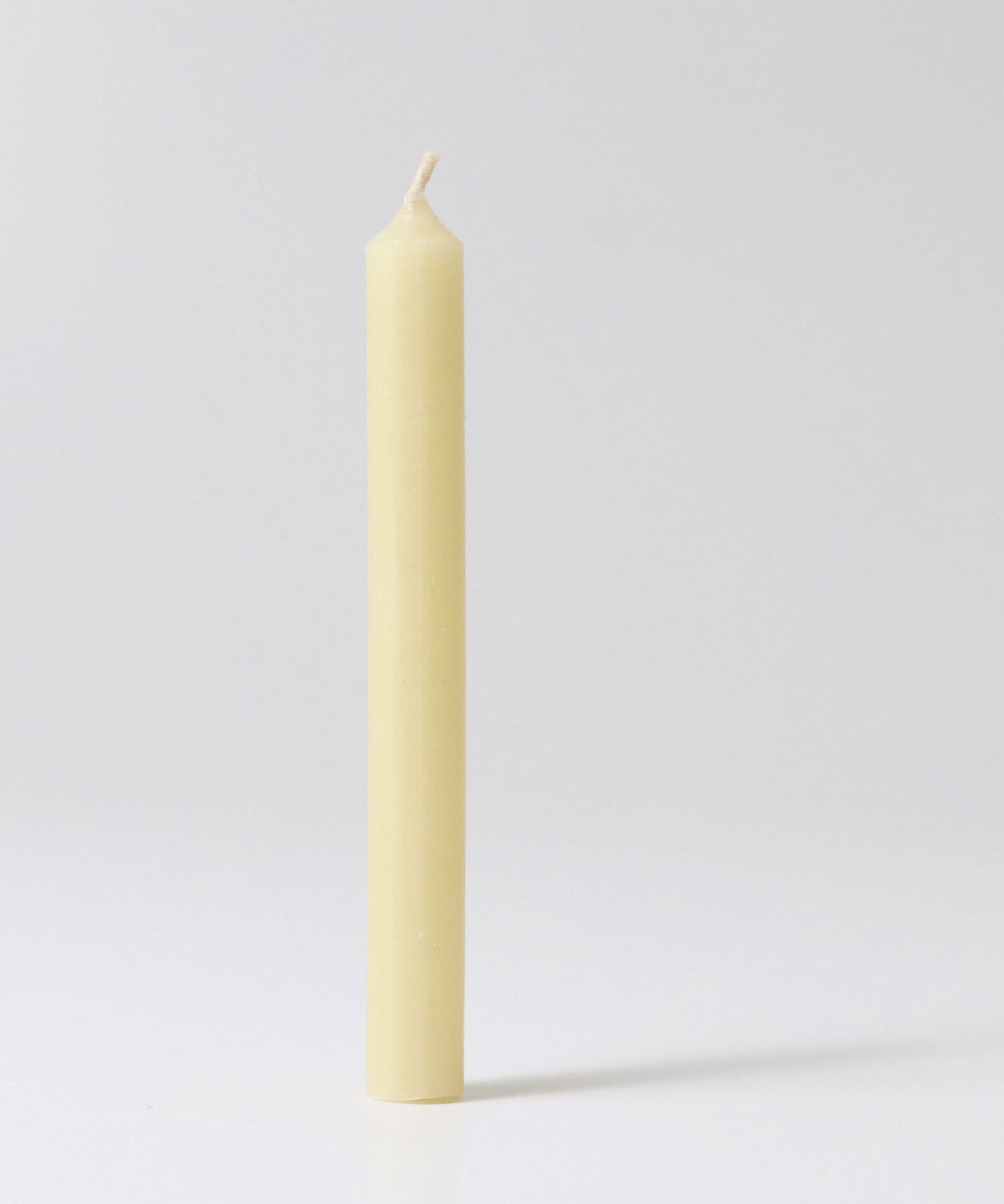 A close up of a single Grimms 100% beeswax candle showing the wick detail