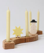 Grimms 100% beeswax candles in brass candle holders slotted in pieces from the decorative ring with a star and snowman figure creating a festive display