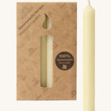 A close up of the Grimms 100% beeswax candles in cream with the cardboard packaging in the background.
