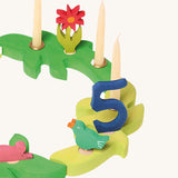 Grimm's Dark Green and Light Green Branches set up in a ring decorated with candles and decorative figures.