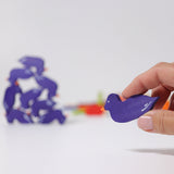 A wooden duck figure from the Grimm's Figures For Counting & Story Telling set in an adult's hand.