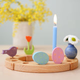 Grimm's pink and blue Floral Duo Easter Eggs Decorative Figure Set. Both eggs are placed on a wooden Grimm's celebration ring with other figures and a blue candle seen in the background.