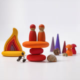 The Grimm's Fire Pebbles Building Set shown amongst a small world play set up alongside Grimm's friends, fire, forest and mushrooms.