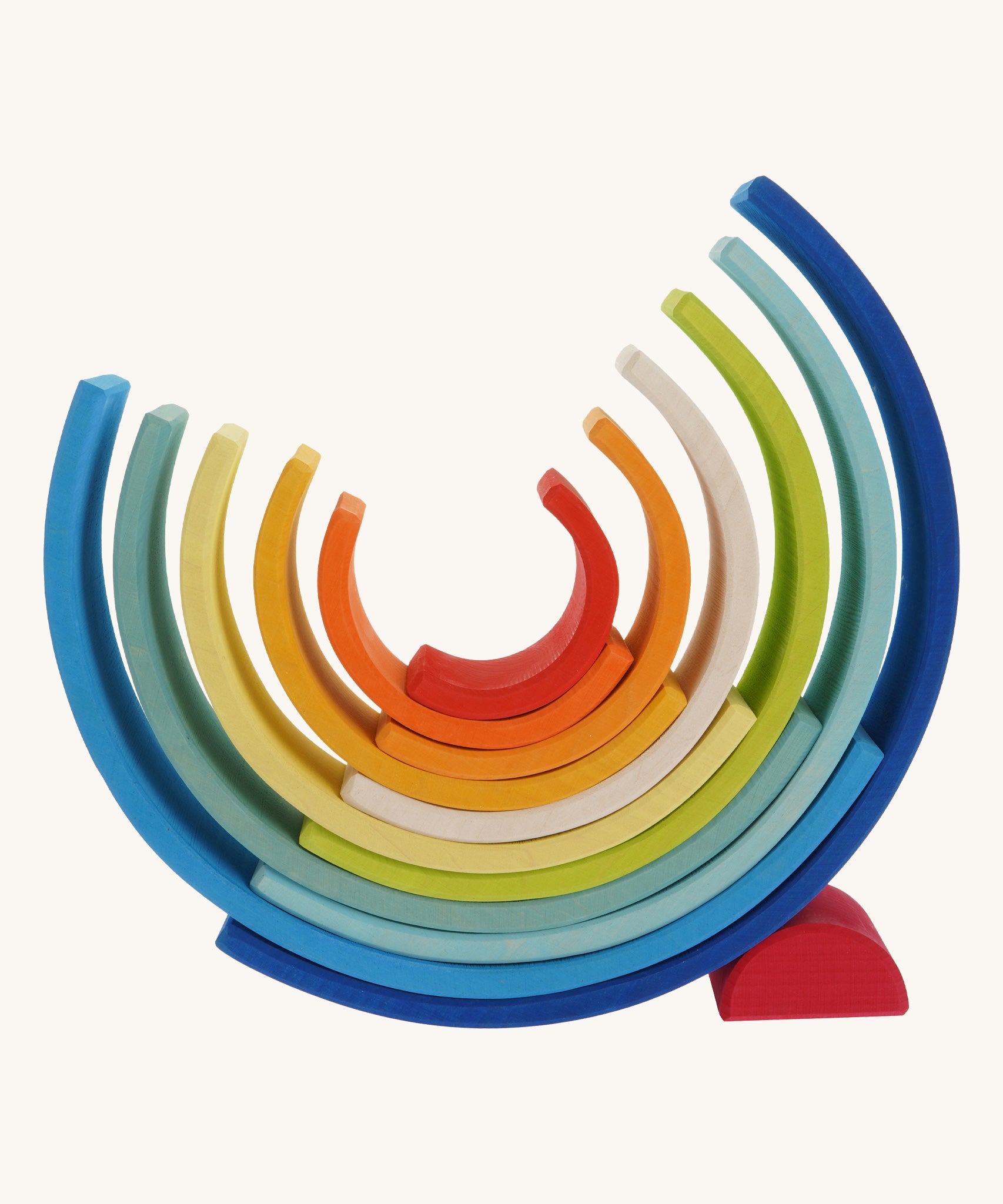The Grimm's Gwawr Sunrise 12 Piece Rainbow on a plain background. The pieces have been placed in an upturned position with the smallest red pieced helping the structure balance.