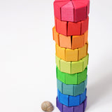 The triangular shaped wooden blocks from the Grimm's Large Octagon Puzzle Set stacked up to create a tower.