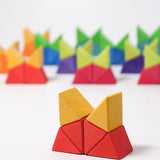 The triangular shaped wooden blocks  from the Grimm's Large Octagon Puzzle set used to create a stack that  resembles a cat's head.